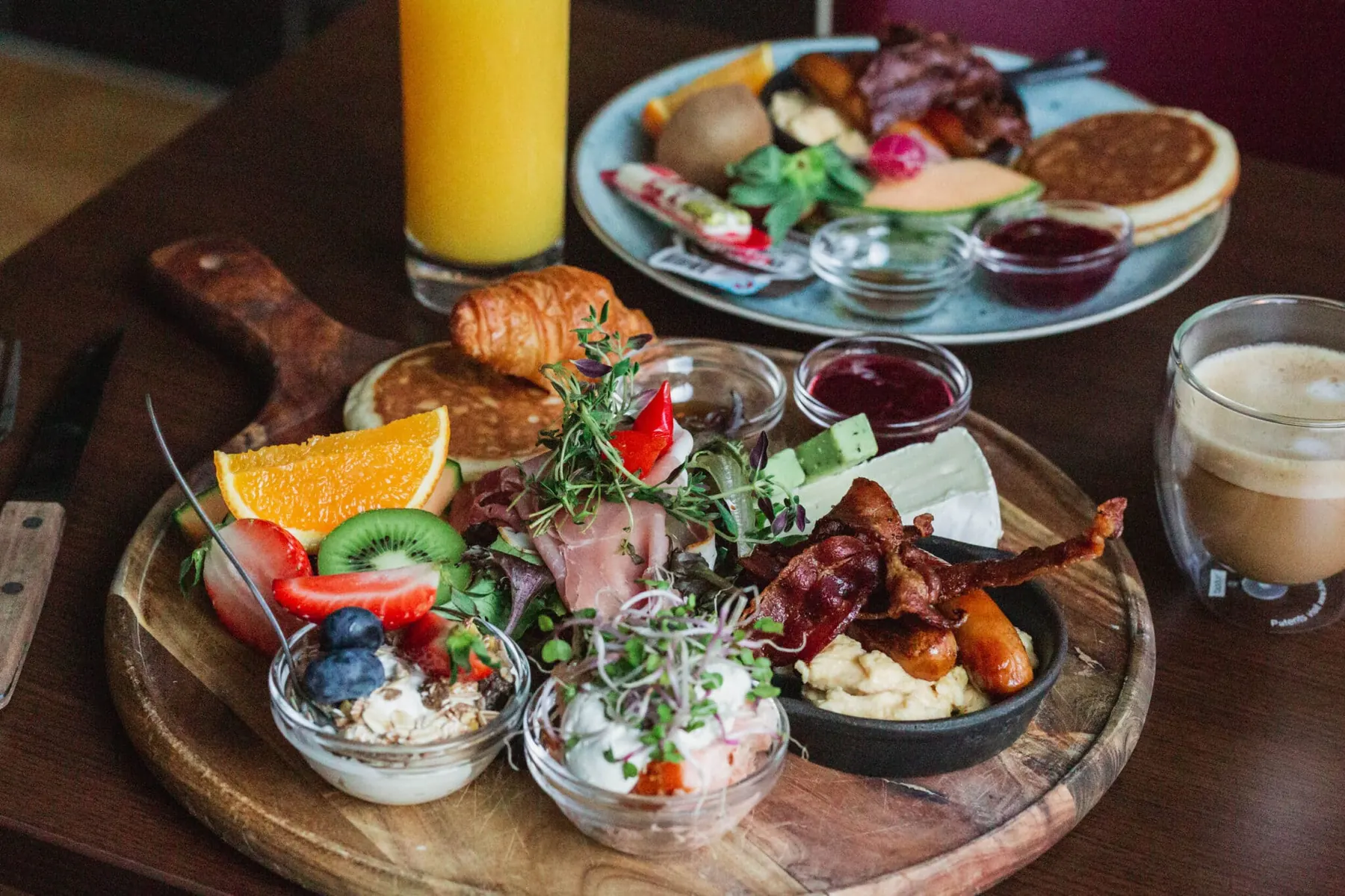 Brunchtallerken med æg, frugt, croissant og juice